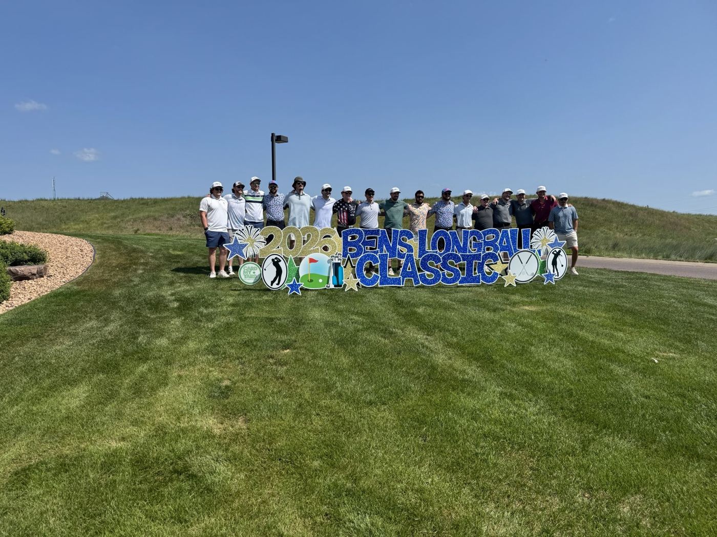 Golfers gathered behind the 2026 Ben's Longball Classic sign at Grand Falls